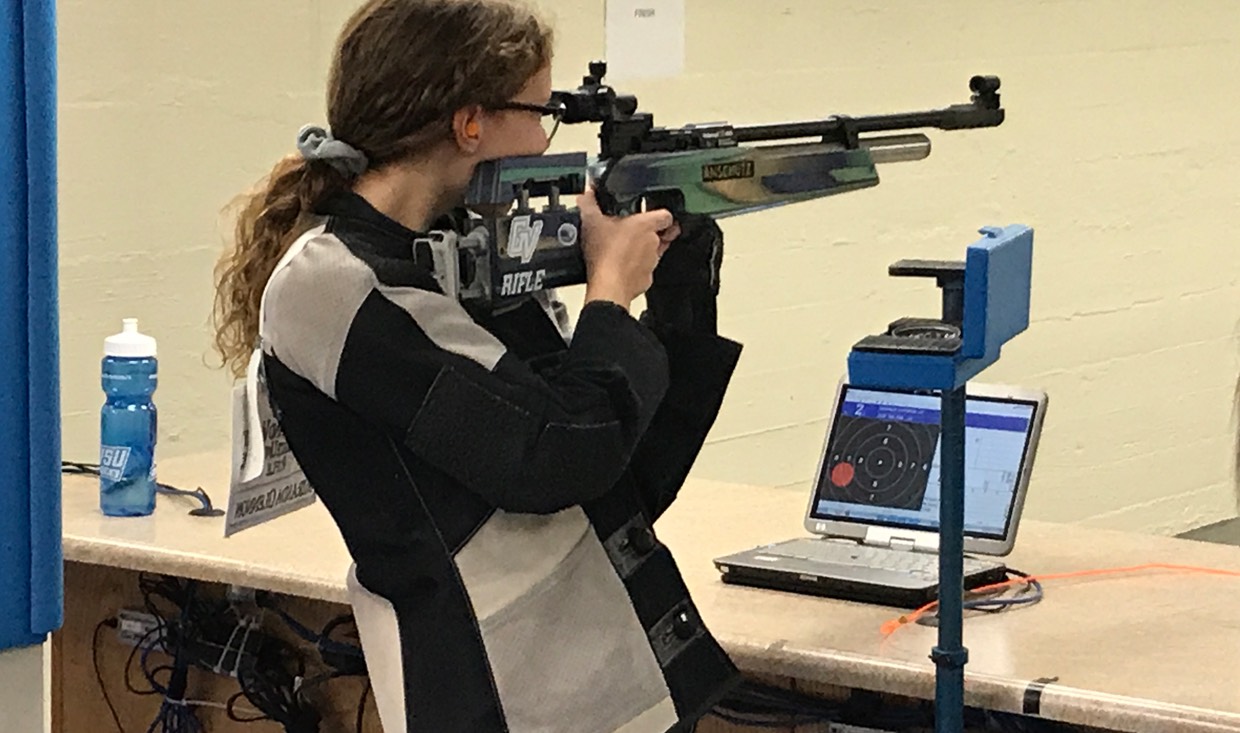 Rifle athlete tracks shot with target software on a computer to report scoring.
